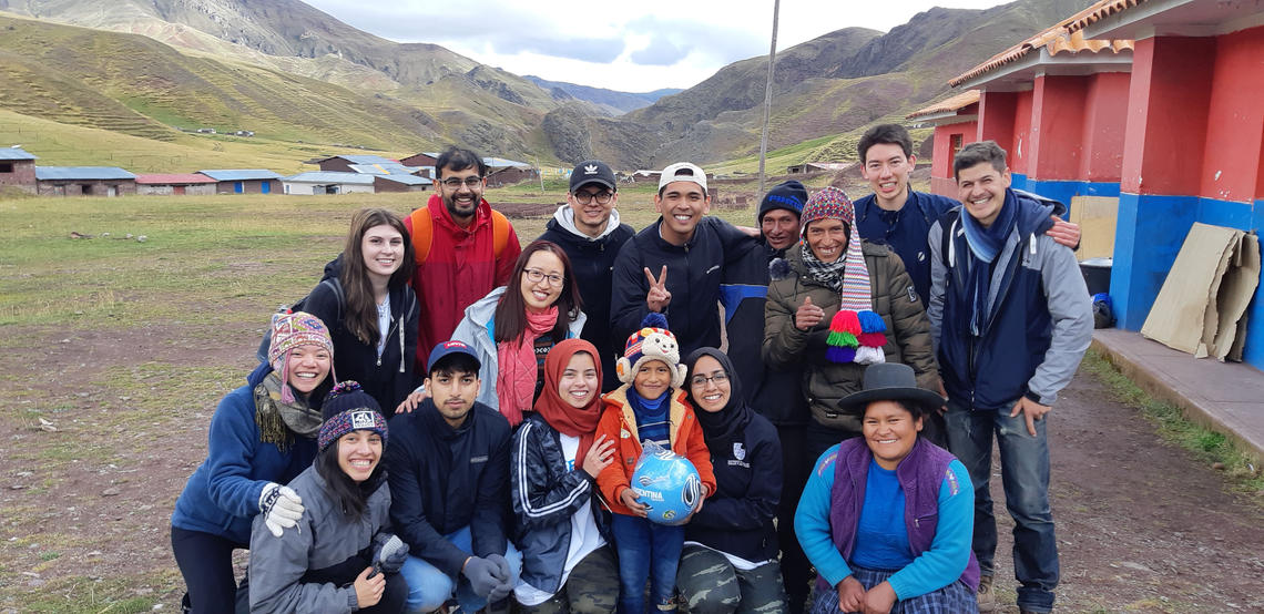 Engineering students pose with villagers in Peru