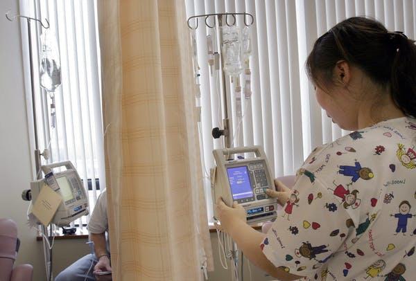 A nurse prepares a patient’s chemotherapy medication
