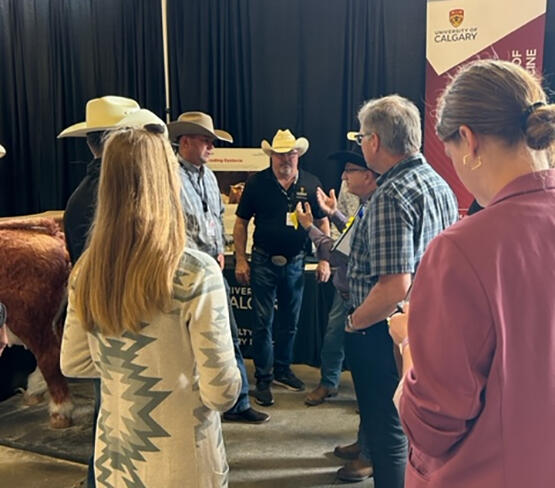 Ed Pajor (centre) hosts Government delegates at the UCVM Calgary Stampede booth.