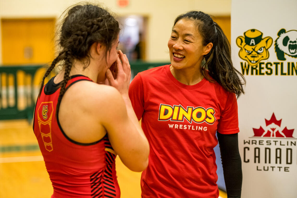 Carol Huynh supporting female Dinos wrestling athlete