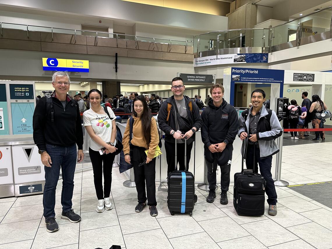 Marc Poulin and student researchers posing at the airport prior to leaving for Chile