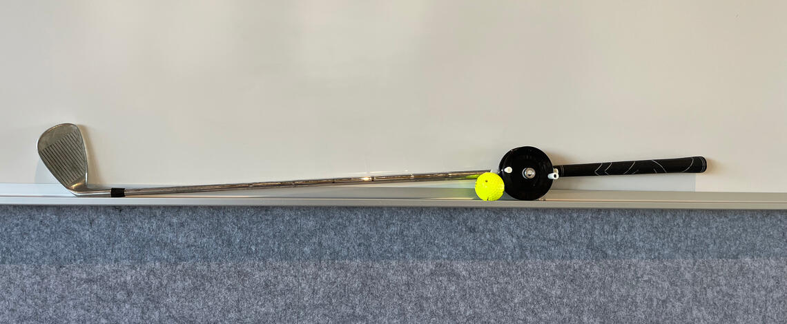 golf club with fishing reel and ball attached