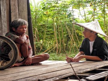 ADZU-SOM student speaking with a village elder. 