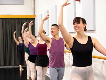 A group of people do ballet on the barre