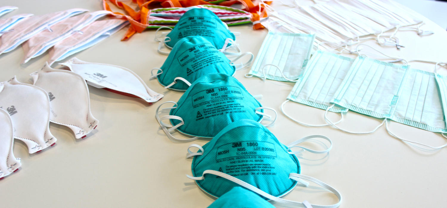 Six types of medical masks used in this study laid out on a table, with focus on the N95 masks