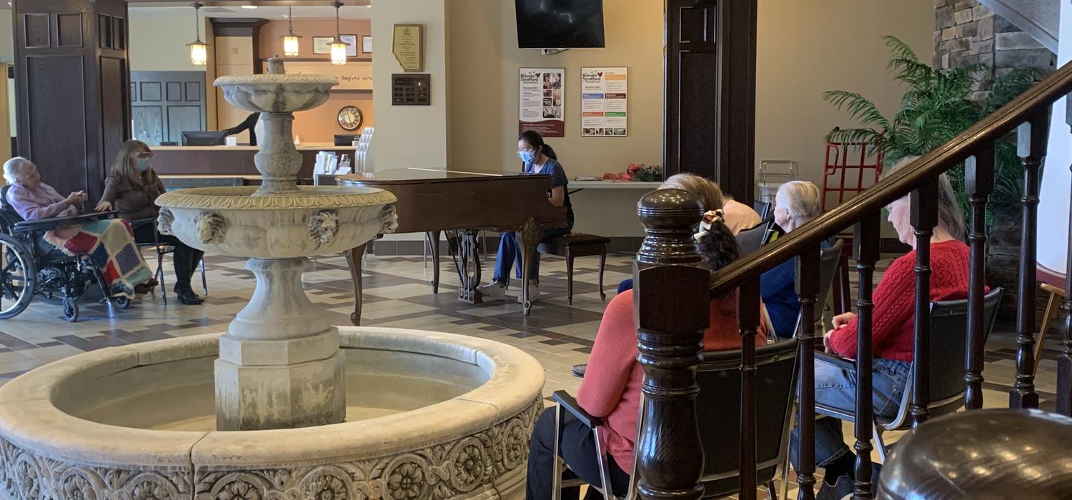 Wang playing piano at Tudor Manor for residents
