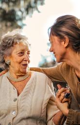 Daughter holds her senior mothers hand outside