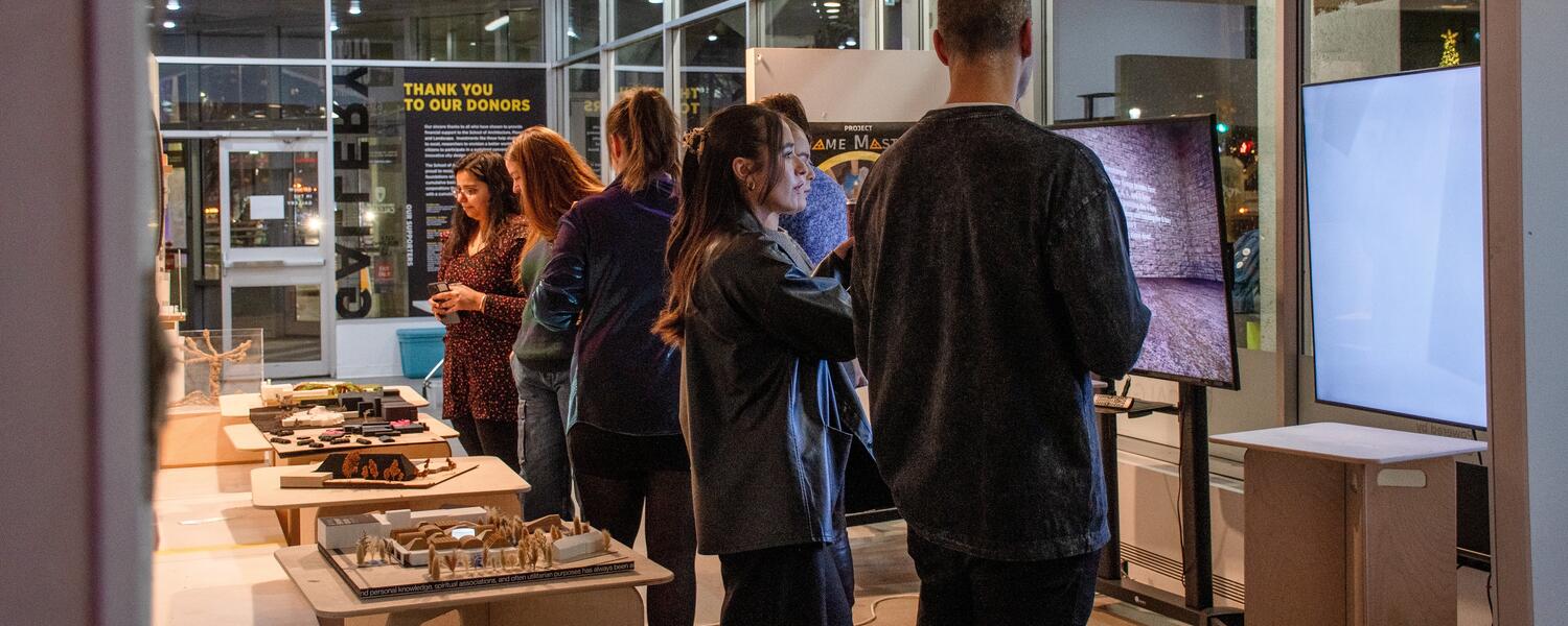 people standing in gallery looking at student work