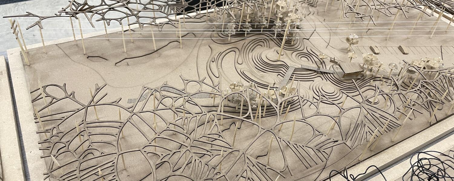 A small scale landscape model of hills and branch-like pillars.