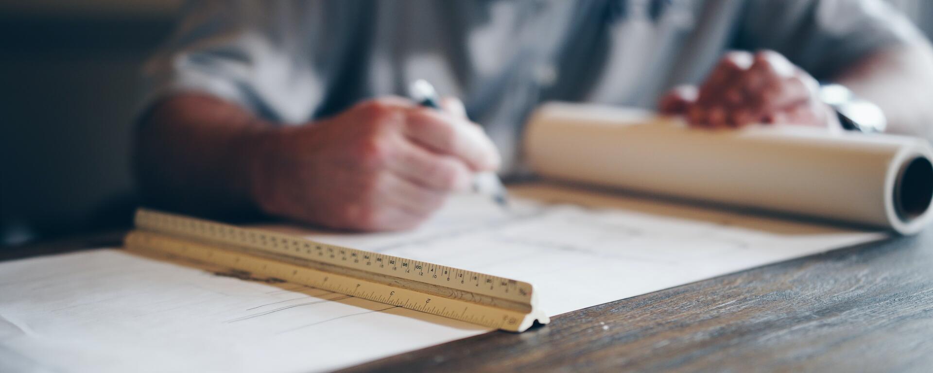 Person drafting on blueprint photo