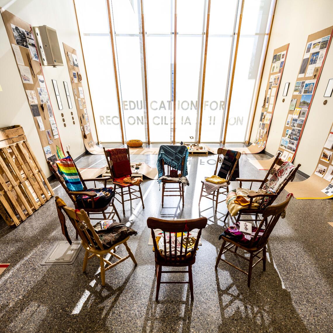 Chairs forming a circle in front of a window that is filled with light from outside.