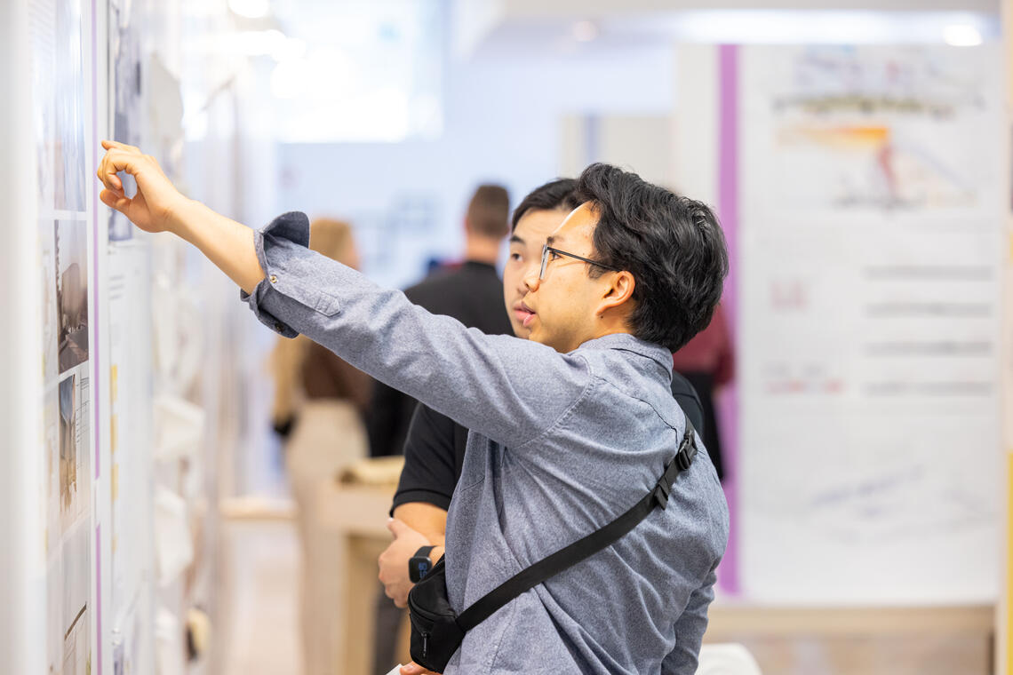 Students looking at posters in the wall, signaling them