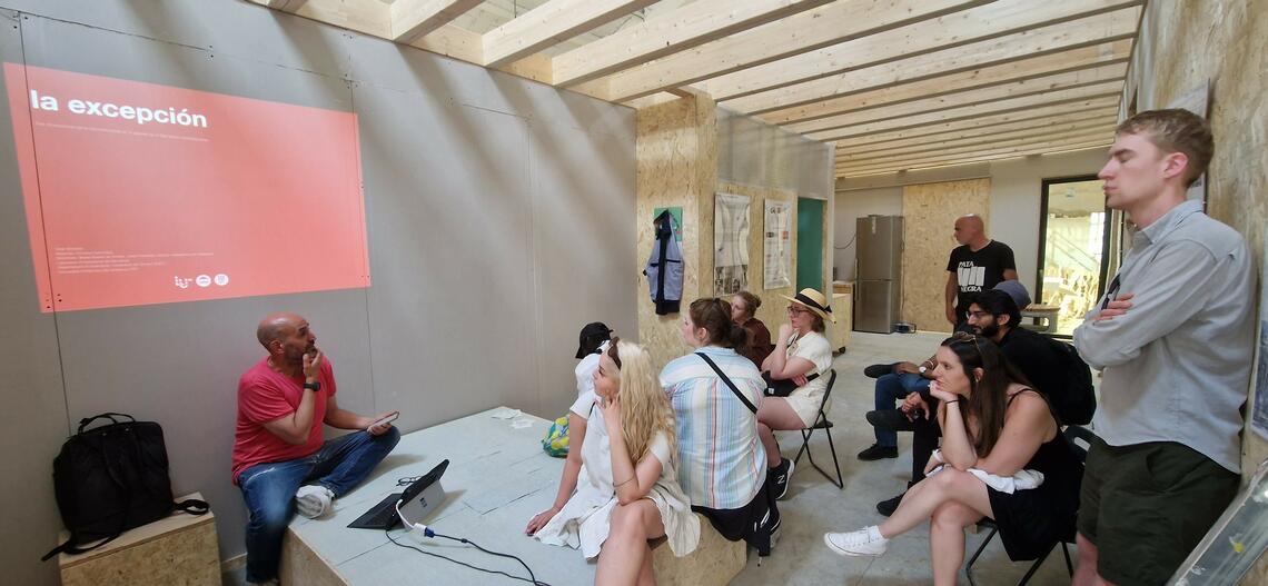 Urbanist Alejandro Giménez gives a lecture to SAPL students inside a prefab dwelling, currently under construction.